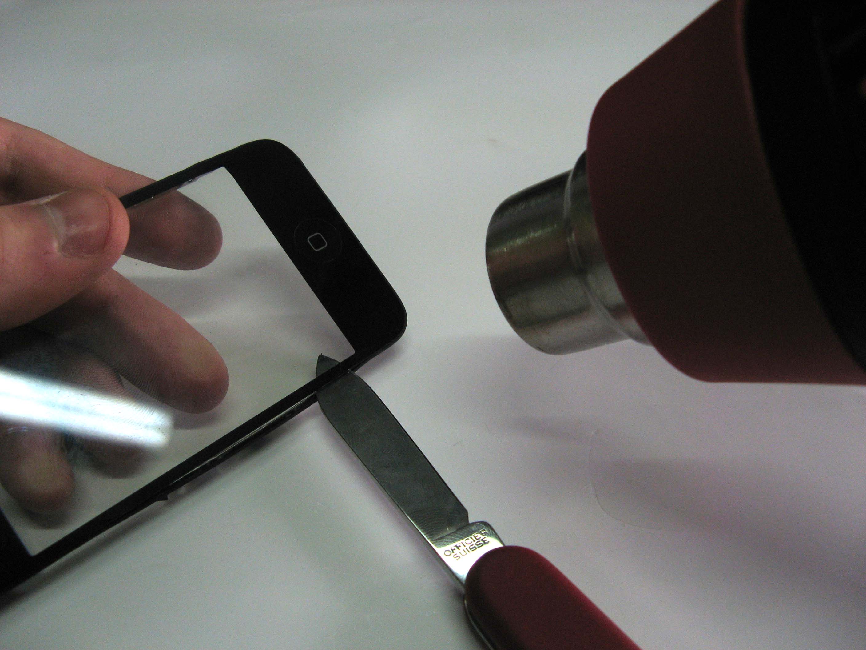 С другой стороны тоже греем и помогаем ножиком в отсоединении стекла iPhone 3G
